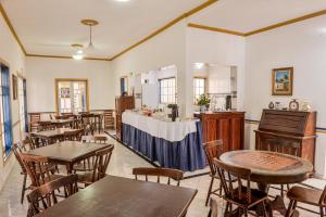 a restaurant with tables and chairs and a counter at Pousada da Tina in Ubatuba