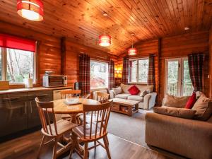 a kitchen and living room with a table and chairs at Rowan Lodge in Strathpeffer
