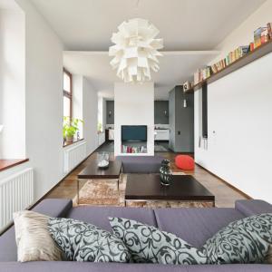 ein Wohnzimmer mit einem lila Sofa und einem Kronleuchter in der Unterkunft Apartament ST1 in Cieszyn