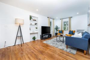 uma sala de estar com um sofá azul e uma televisão em Lovely Ranch House in Windsor, 10 mins to Hartford Connecticut em Windsor