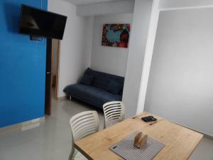 ein Esszimmer mit einem Tisch und Stühlen mit einem blauen Sofa in der Unterkunft Azul departamento 34 m2 Nuevo in Jiutepec