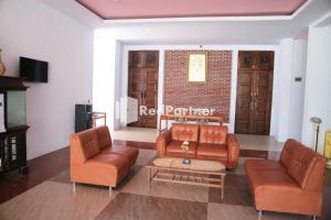 a living room with two couches and a coffee table at Wisma Suci Syariah Polewali Mandar Mitra RedDoorz in Matakali