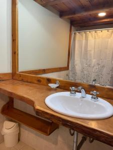 a bathroom with a sink and a mirror at Villa del Lago in San Carlos de Bariloche