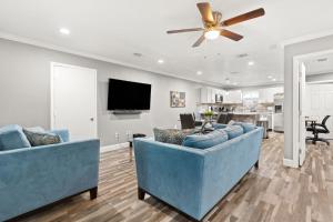 een woonkamer met twee blauwe banken en een tv bij CYC Mega House with BBQ Gazebo in San Antonio