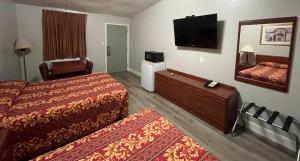 a hotel room with two beds and a flat screen tv at Hamilton Inn in Hamilton