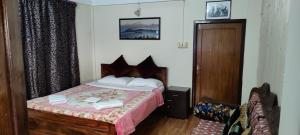 a bedroom with a bed and a wooden door at The River View Homestay in Kurseong