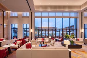 een lobby met banken, tafels en ramen bij Gran Melia Chengdu in Chengdu