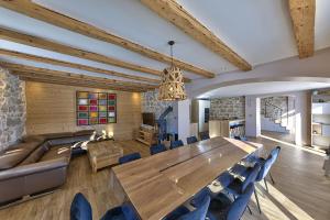 a dining room with a large wooden table and blue chairs at Maison idéalement placée vue magnifique, départ ski de fond/Randonnée depuis le jardin in Les Rousses