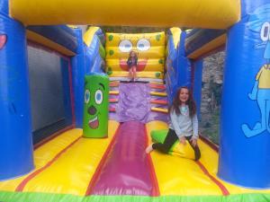 a woman sitting on a inflatable slide in a bounce house at Cal Pastor in Fornells de la Muntanya