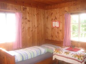 ハイリゲンブルートにあるAlmhütte Gorgasserのログキャビン内のベッドルーム1室(ベッド2台付)