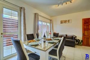 a dining room with a table and chairs at Appartement LES CHARMES DU NORD, classé 4 étoiles, rez-de-chaussée, jardin, 4 personnes, Sainte Clotilde, Saint Denis in Sainte-Clotilde