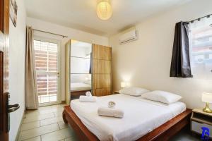 a bedroom with a bed with two towels on it at Appartement LES CHARMES DU NORD, classé 4 étoiles, rez-de-chaussée, jardin, 4 personnes, Sainte Clotilde, Saint Denis in Sainte-Clotilde
