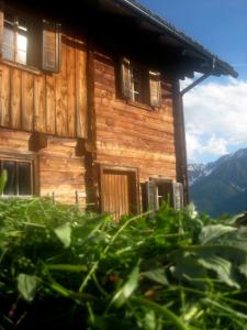 a log cabin with mountains in the background at Almhütte Gorgasser in Heiligenblut
