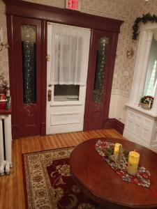 a living room with a wooden table and a door at Marmora and Lake Inn and Victorian Diner in Marmora