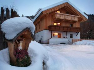 フェンデルスにあるCozy Apartment in Fendels near Ski Areaの雪屋根のログキャビン