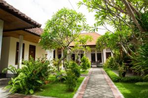 una casa con un jardín delante de ella en Manda Homestay, en Sanur
