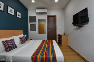 a bedroom with a large bed and a flat screen tv at Hotel Silver Saffron Near Paschim Vihar Metro Station in New Delhi