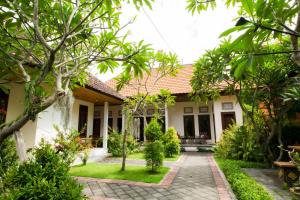 a house with a garden and a courtyard at Manda Homestay in Sanur