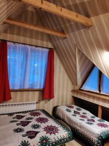 Marynka في زاكوباني: غرفة نوم بسريرين في غرفة بها نوافذ