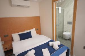 a bedroom with a bed with towels on it at Saatlı Hotel in Çeşme