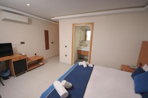 a large bedroom with a bed and a television at Saatlı Hotel in Çeşme