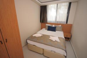 a small bedroom with a bed with two pillows at Saatlı Hotel in Çeşme