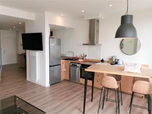 a kitchen with a wooden table and a refrigerator at VILLA Henry - FOCH in Les Sables-dʼOlonne +23 photos