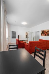 a living room with a table and red couches at Apartment Yogiam in Slavkov u Brna