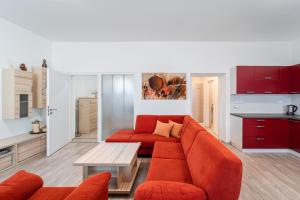 布爾諾附近斯拉夫科夫的住宿－Apartment Yogiam，客厅配有橙色沙发和桌子