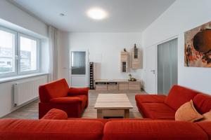 una sala de estar con 2 sofás rojos y una mesa. en Apartment Yogiam, en Slavkov u Brna