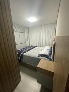 - une petite chambre avec un lit et des oreillers dans l'établissement Studio 703 - Ravenna Residence, à Itajaí