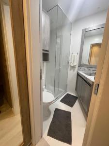 une salle de bain avec toilettes et douche en verre dans l'établissement Studio 703 - Ravenna Residence, à Itajaí