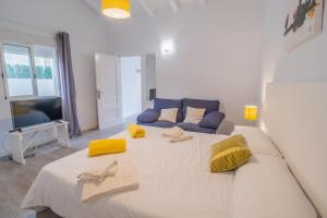 a large white bed in a room with a couch at E368 Casa Blanca by Mallorca Villa Selection in Alcudia