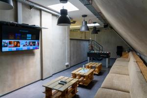 a living room with a couch and tables and a tv at Main Square Hostel in Zagreb