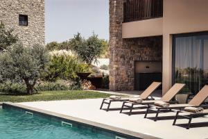 a swimming pool with two lounge chairs next to a house at Villas Misto in Primošten