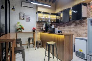 uma cozinha com um bar e bancos num restaurante em RedDoorz Plus @ Jalan Juanda Medan em Medan