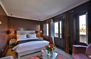 una camera con un grande letto e un divano di Riad Dar One a Marrakech