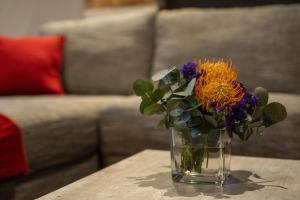un jarrón de flores sentado en una mesa en Lilian Lofts Hotel & Spa en Johannesburgo