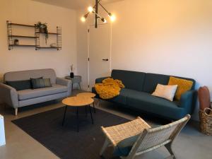 sala de estar con sofá azul y mesa en Villa veld en velo, en Bree