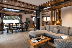 a living room with a couch and a table at Chalet Saint Maurice - piscine privée & jacuzzi in Champagny-en-Vanoise