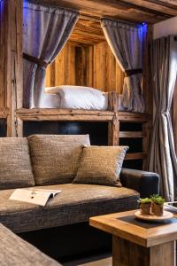 a living room with a couch and a bed at Chalet Saint Maurice - piscine privée & jacuzzi in Champagny-en-Vanoise