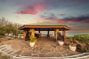 un cenador con mesa y sillas junto al océano en PrideInn Flamingo Beach Resort & Spa Mombasa en Mombasa