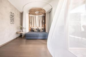 ein Schlafzimmer mit einem blauen Bett und einem Spiegel in der Unterkunft ALPIANA - green luxury Dolce Vita Hotel in Völlan