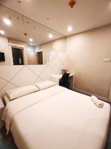 a bedroom with a large white bed and a mirror at CAPITAL EXPRESS in Kota Kinabalu