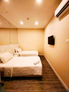 a hotel room with two beds and a television at CAPITAL EXPRESS in Kota Kinabalu