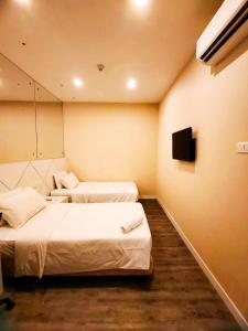 コタキナバルにあるCAPITAL EXPRESSのベッド2台とテレビが備わるホテルルームです。