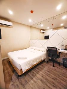 a bedroom with a bed and a desk and a computer at CAPITAL EXPRESS in Kota Kinabalu
