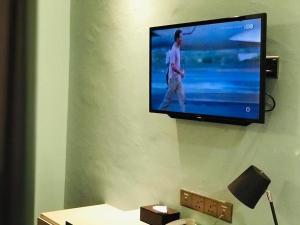 einen Flachbild-TV, der an einer Wand hängt in der Unterkunft K Hotel in Kota Kinabalu