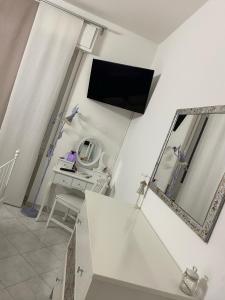 ein Wohnzimmer mit einem TV an der Wand und einem Tisch in der Unterkunft Polly in Rapallo