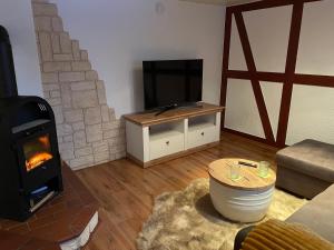 ein Wohnzimmer mit einem Kamin und einem Flachbild-TV in der Unterkunft Ferienhaus Gerswalde in Gerswalde
